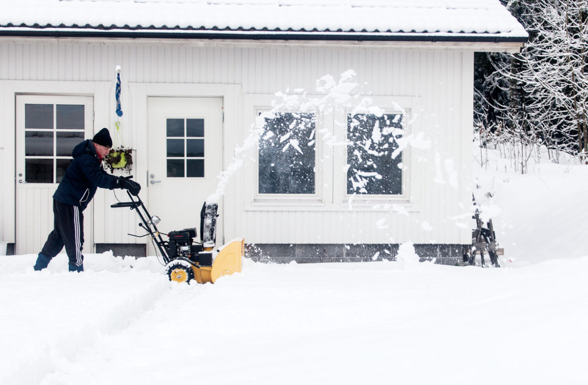 Man plogar snö med maskin