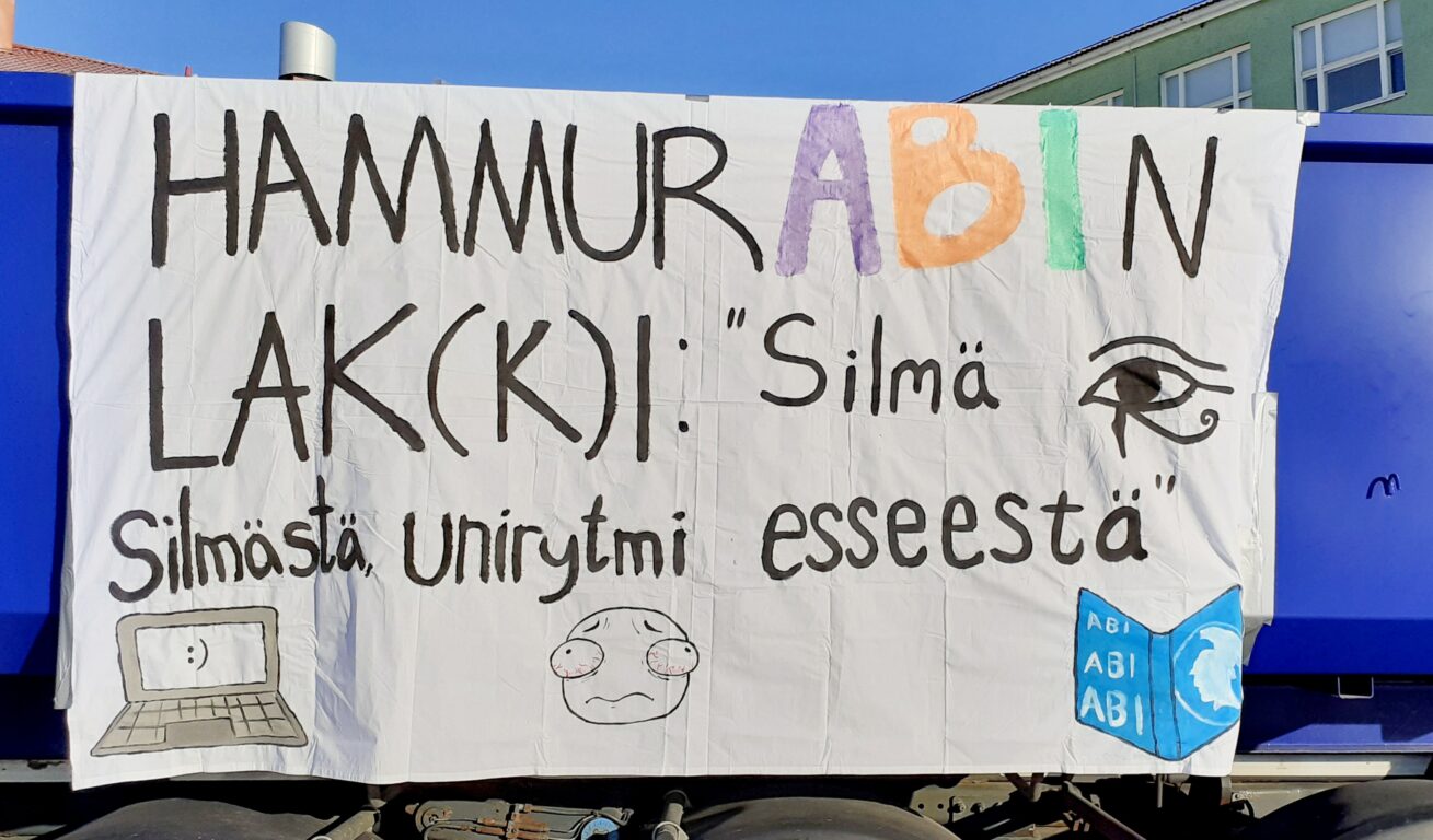 Abien rekkajuliste, jossa lukee "Hammurabin lak(k)i: "Silmä silmästä, unirytmi esseestä."